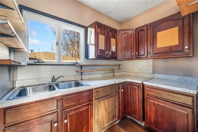 kitchen with a textured ceiling, tasteful backsplash, dark wood-type flooring, and sink