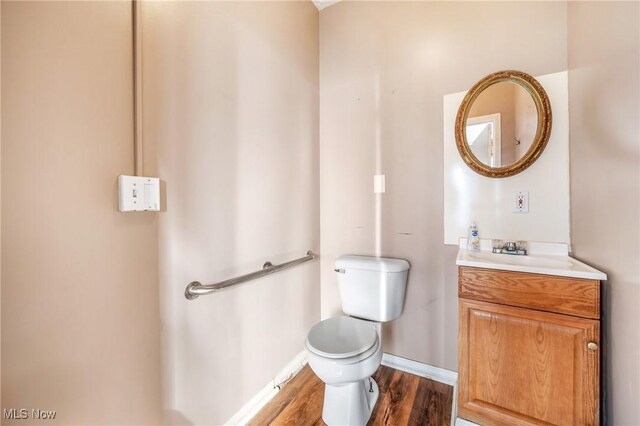 bathroom with hardwood / wood-style flooring, vanity, and toilet