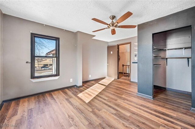 unfurnished bedroom with hardwood / wood-style floors, ceiling fan, and a textured ceiling