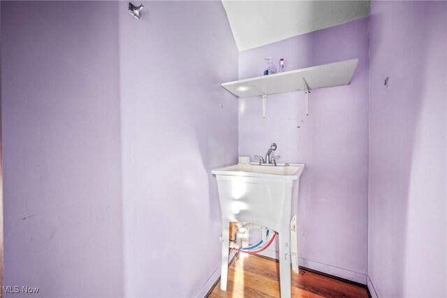 bathroom featuring hardwood / wood-style floors and lofted ceiling