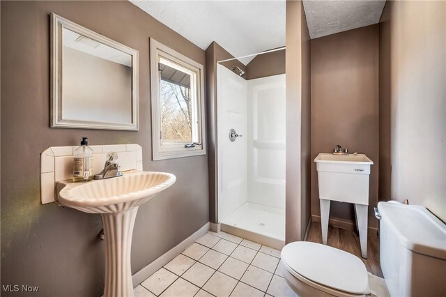 bathroom with tile patterned flooring, sink, toilet, and a shower