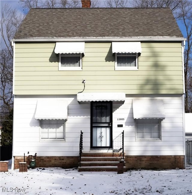 view of snow covered rear of property