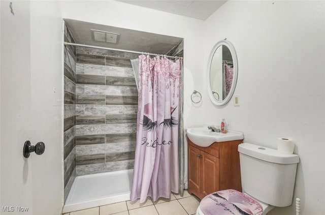 bathroom featuring tile patterned floors, vanity, toilet, and walk in shower