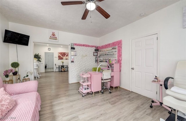 office featuring ceiling fan, light hardwood / wood-style floors, and a textured ceiling