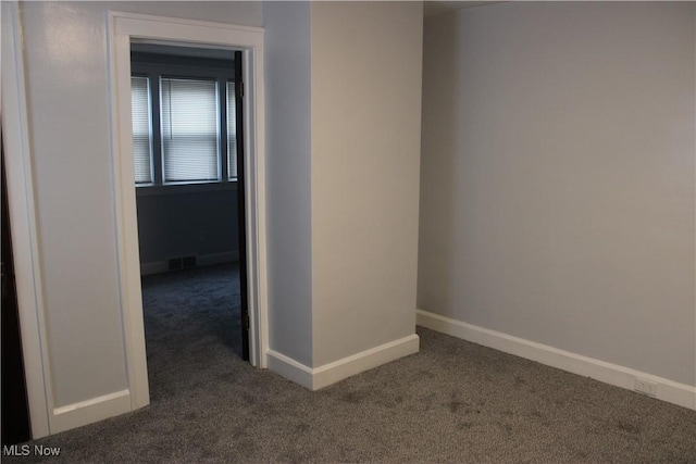 spare room with dark carpet