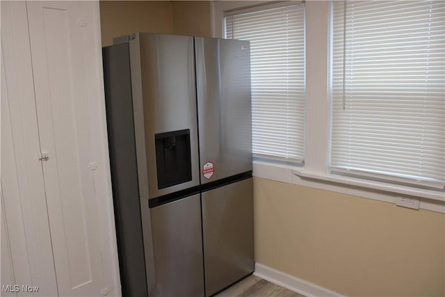 kitchen featuring stainless steel fridge and light hardwood / wood-style flooring