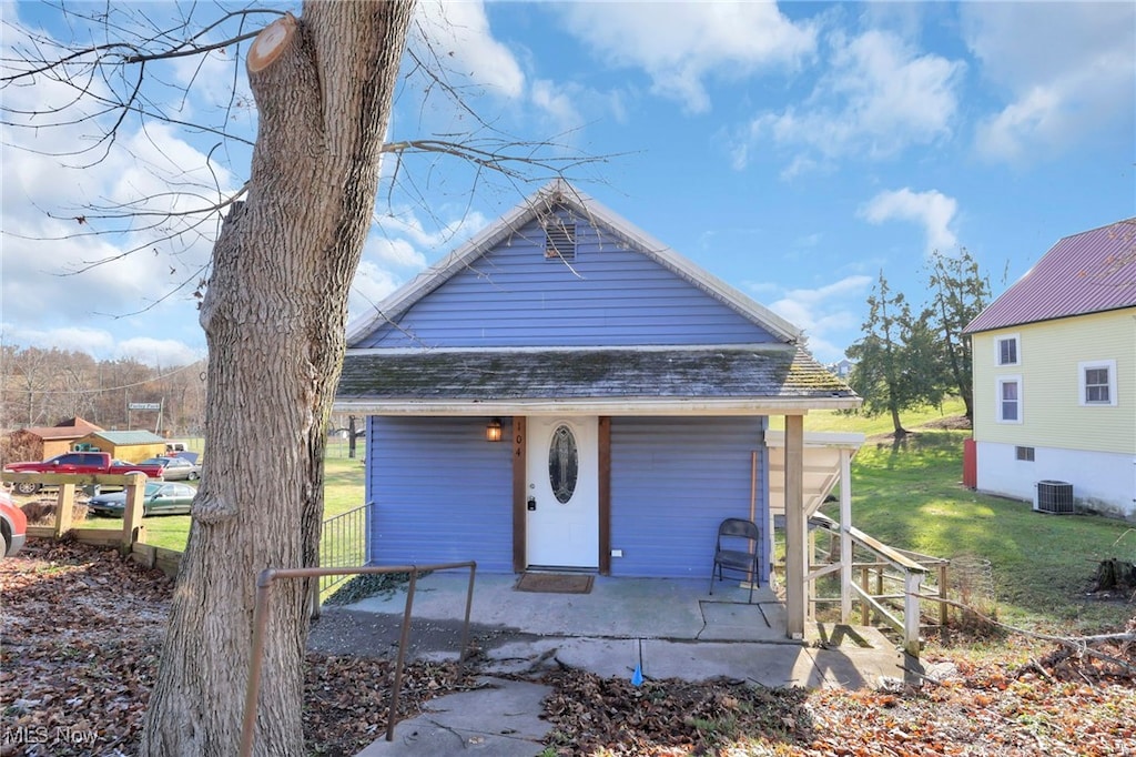 view of front of home with cooling unit and a front lawn