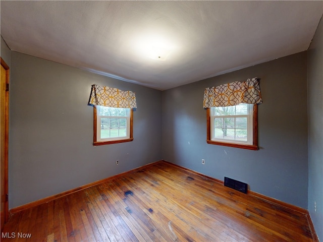 empty room featuring hardwood / wood-style floors and a healthy amount of sunlight