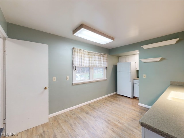 kitchen featuring white cabinets, white fridge, and light hardwood / wood-style floors