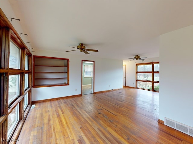 unfurnished living room with ceiling fan, light hardwood / wood-style flooring, and a healthy amount of sunlight