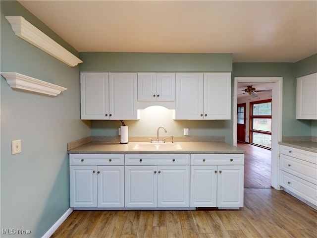 kitchen featuring white cabinetry, sink, ceiling fan, and light hardwood / wood-style floors