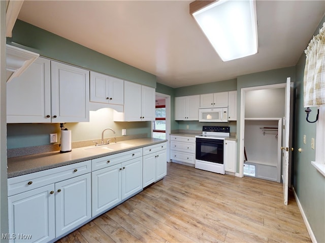 kitchen with white cabinetry, white appliances, sink, and light hardwood / wood-style flooring