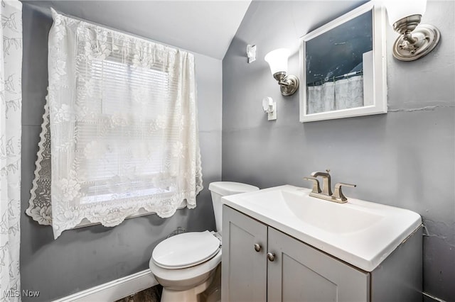 bathroom with vanity, toilet, and vaulted ceiling