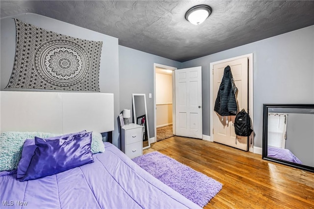 bedroom with hardwood / wood-style floors and a textured ceiling