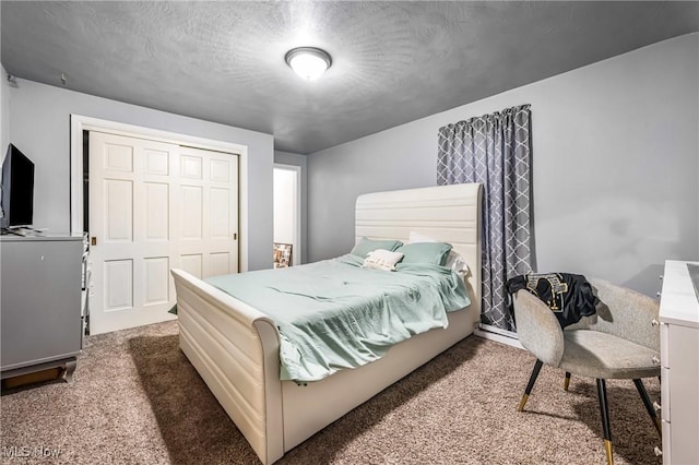 bedroom with a closet, carpet, and a textured ceiling