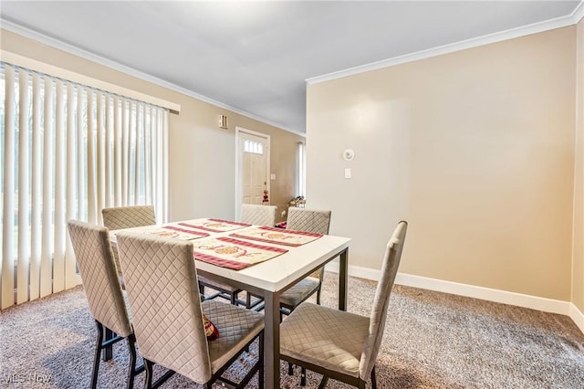 carpeted dining room with ornamental molding