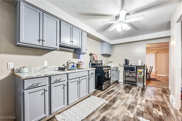 kitchen featuring ceiling fan, sink, hardwood / wood-style floors, and appliances with stainless steel finishes