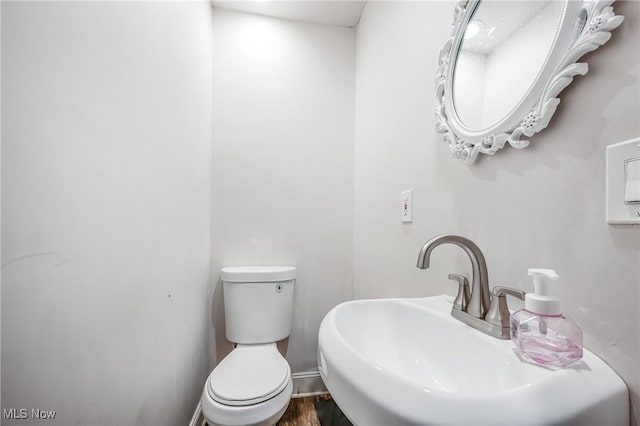 bathroom featuring hardwood / wood-style flooring, toilet, and sink