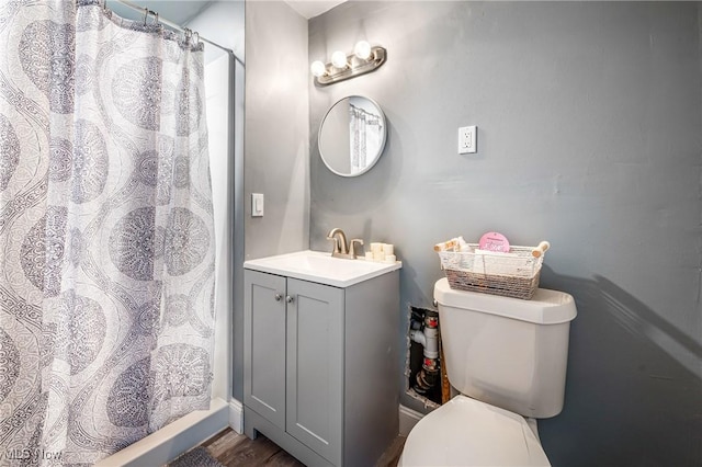 bathroom featuring a shower with shower curtain, hardwood / wood-style floors, vanity, and toilet