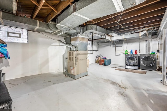 basement featuring heating unit and washer and clothes dryer