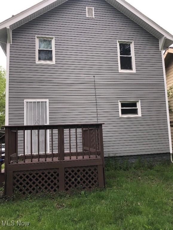 rear view of property with a lawn and a wooden deck