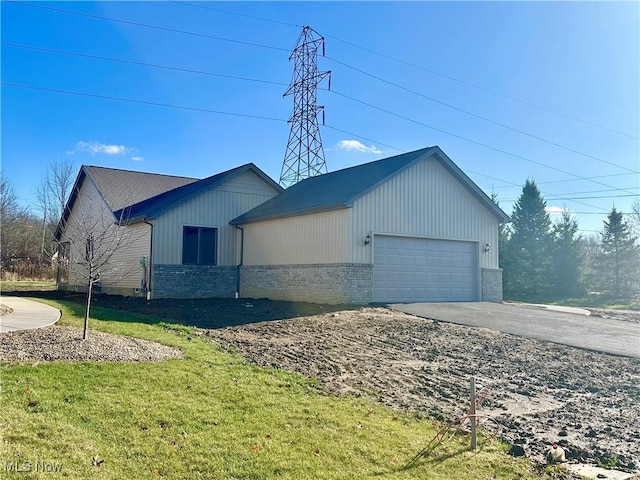 view of side of property featuring a garage and a lawn