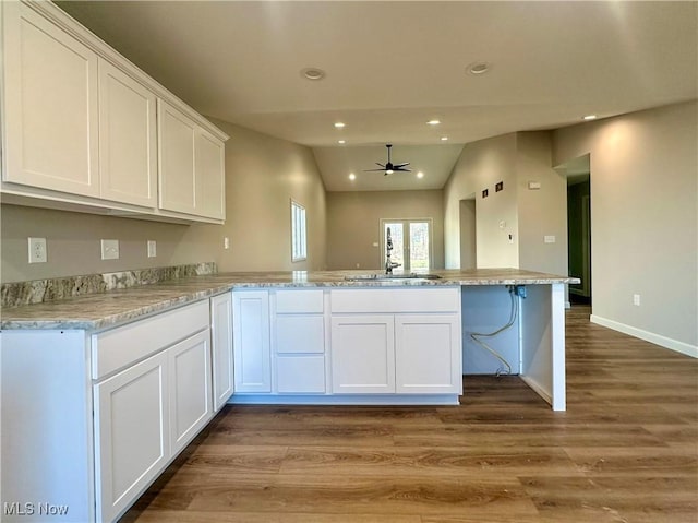 kitchen featuring ceiling fan, white cabinets, lofted ceiling, and hardwood / wood-style flooring