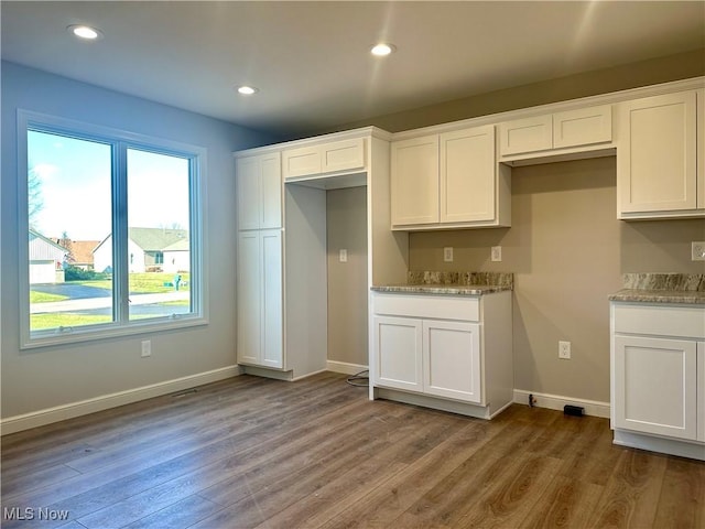 kitchen with dark hardwood / wood-style flooring and white cabinetry