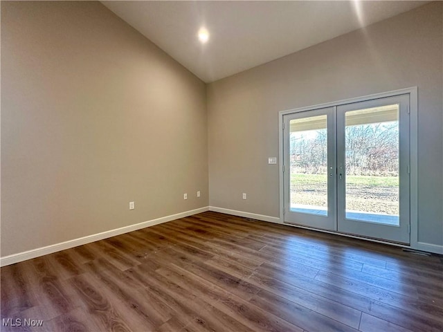 spare room with french doors, dark wood-type flooring, and vaulted ceiling