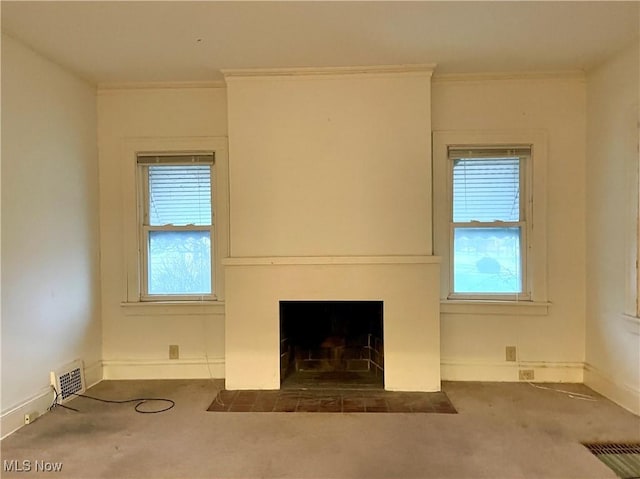 unfurnished living room with crown molding and dark carpet