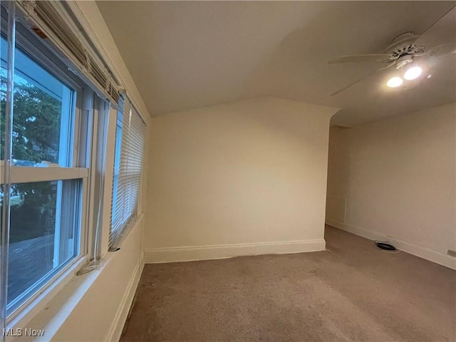 carpeted spare room with ceiling fan and vaulted ceiling