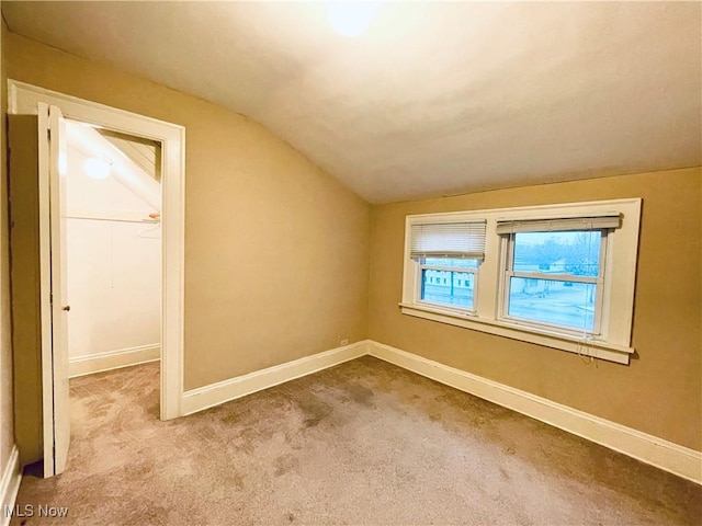 additional living space featuring light carpet and vaulted ceiling