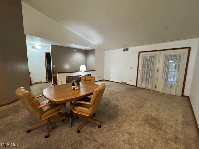 dining room with carpet and vaulted ceiling