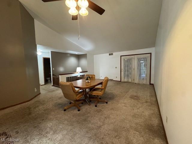 dining space featuring light carpet, high vaulted ceiling, and ceiling fan