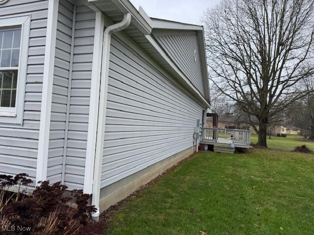 view of home's exterior with a lawn and a deck