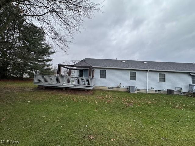 back of house with cooling unit, a yard, and a wooden deck