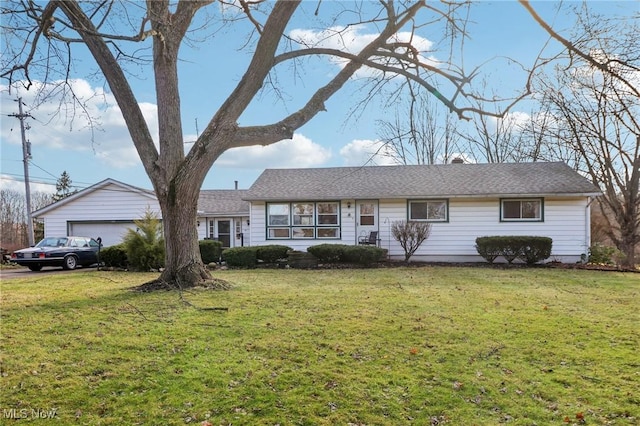 single story home featuring a garage, an outbuilding, and a front lawn