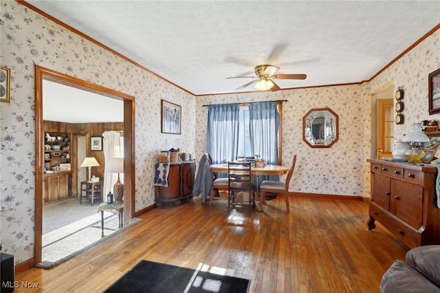 dining room with ceiling fan, wood-type flooring, a textured ceiling, and ornamental molding