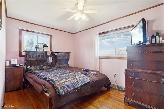 bedroom featuring ceiling fan, crown molding, and light hardwood / wood-style floors