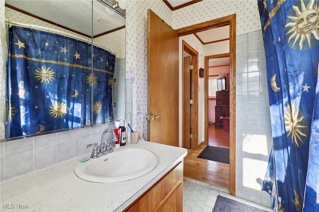 bathroom with a shower with shower curtain, hardwood / wood-style floors, vanity, and ornamental molding