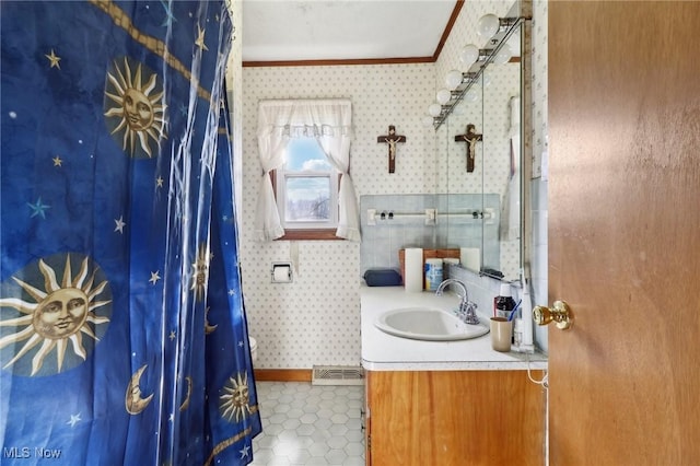 bathroom featuring tile patterned flooring, vanity, and crown molding