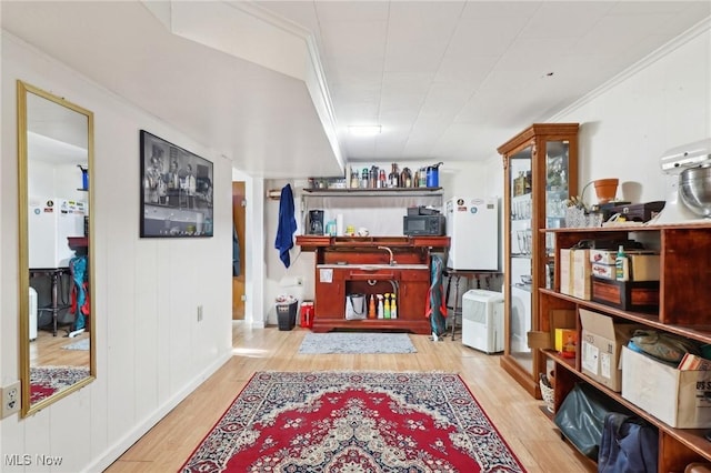 miscellaneous room featuring ornamental molding and light wood-type flooring