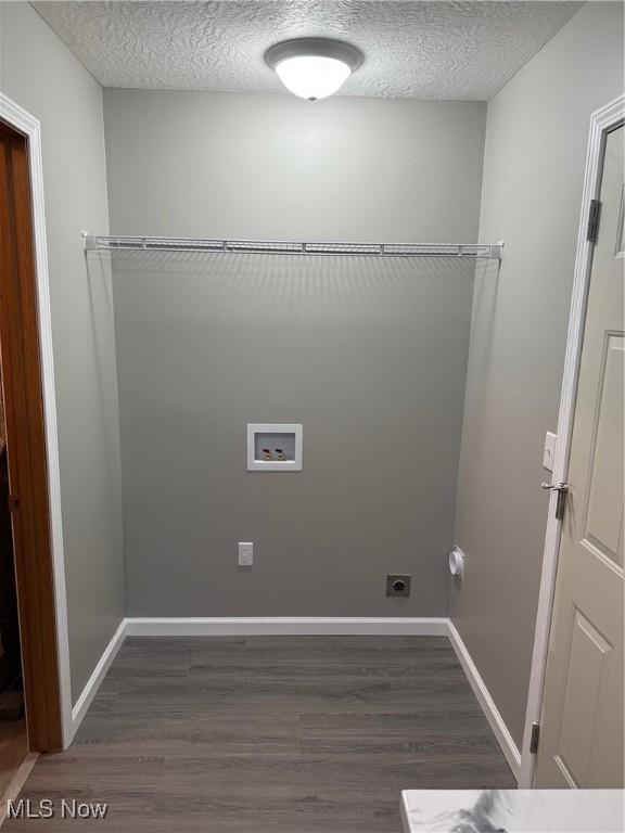 clothes washing area featuring dark hardwood / wood-style flooring, washer hookup, a textured ceiling, and hookup for an electric dryer