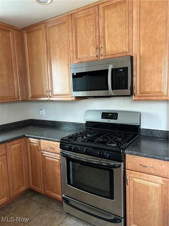 kitchen featuring stainless steel appliances and light tile patterned floors