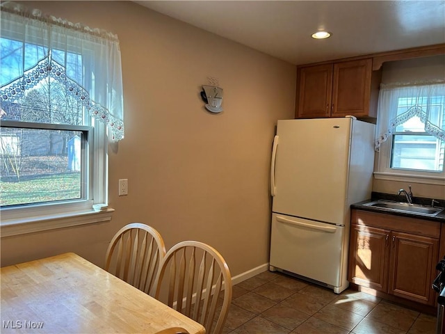 kitchen with white fridge, sink, and tile patterned floors