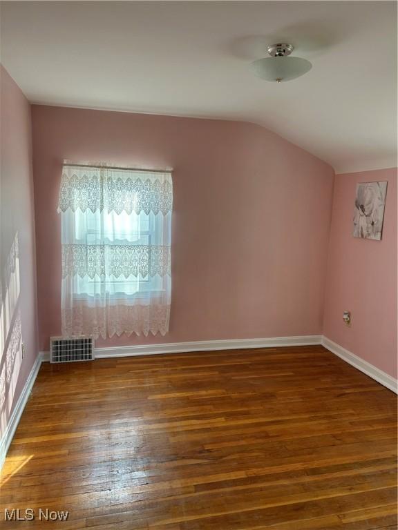 bonus room with dark wood-type flooring and lofted ceiling