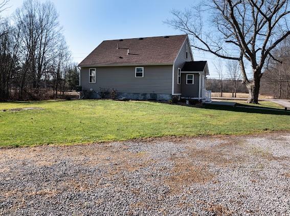 rear view of property featuring a lawn