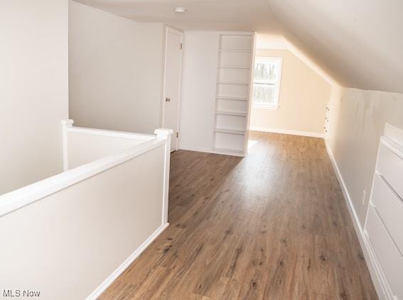 additional living space with dark hardwood / wood-style flooring and lofted ceiling