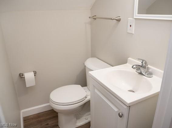 bathroom featuring vanity, wood-type flooring, and toilet