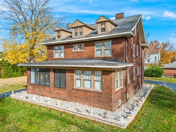 159 Kenilworth Ave SE, Warren, OH 44483 - rear view of property with brick siding, a chimney, and a yard